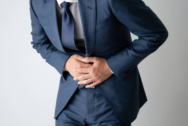 胃痛を発症している男性