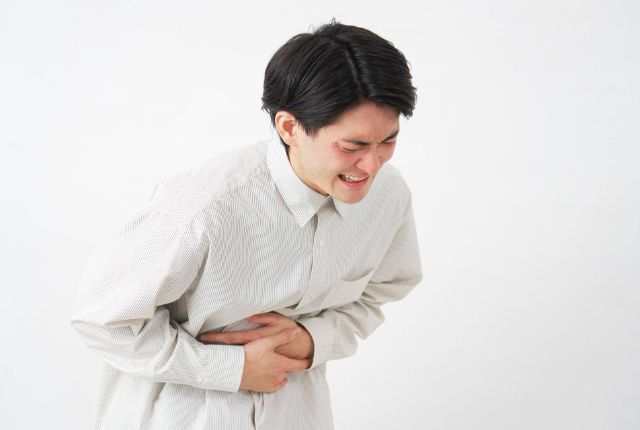 胃痛を発症している男性